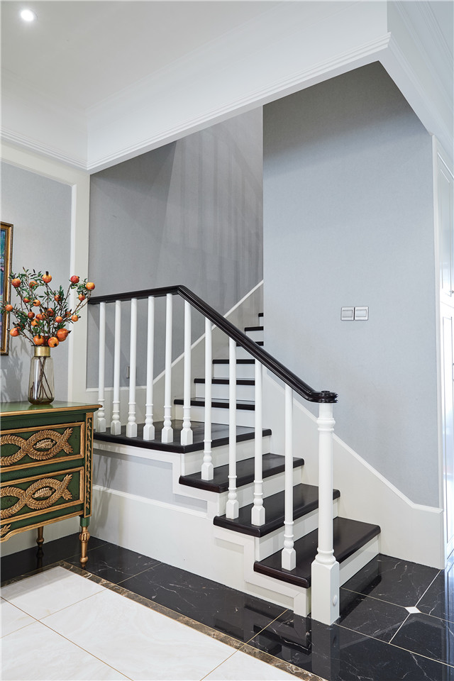 楼梯是连贯生活各个空间的桥梁,黑色瓷砖与白色边栏搭配和谐自然.